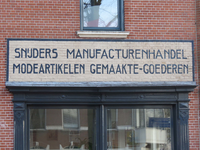 838860 Afbeelding van de buitenreclame met de tekst 'Snijders Manufacturenhandel Modeartikelen Gemaakte-Goederen', op ...